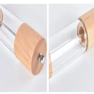 Close-up of oak and acrylic pepper grinder showing wood grain and transparent body.