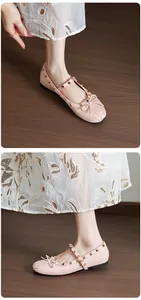 Detailed view of pink Mary Jane ballet flats with gold studs and bow detail.