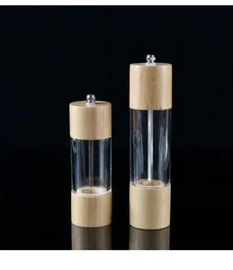 Close-up view of manual pepper grinders made of oak wood and transparent acrylic
