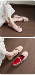Close-up of pink Mary Jane ballet flats with gold studs and bow detail on a wooden floor