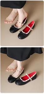 Detailed macro view of black ballet Mary Jane flats featuring studded straps and elegant bows