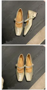 Top-down view of champagne gold Mary Jane shoes with elegant rhinestone straps on dark wood