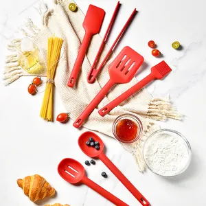 Set de 6 ustensiles de cuisine en silicone rouge sur une surface en marbre chic