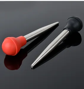 Close-up detail of stainless steel turkey baster with red and black silicone bulbs.