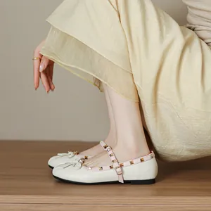 Elegant cream-colored Mary Jane ballet flats with pink rivet straps and cute bow detail