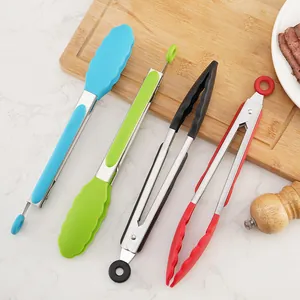 Set of colorful silicone food tongs for barbecue and steak on a wooden board