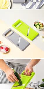 Detailed close-up of green and grey handheld vegetable slicer slicing a fresh cucumber
