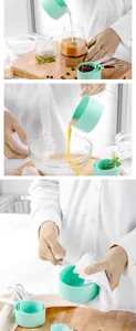 Macro view of mint green measuring cups being used for baking and pouring fresh milk.