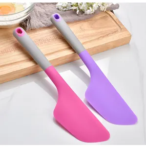 Two large silicone spatulas in pink and purple for baking and cake decorating details