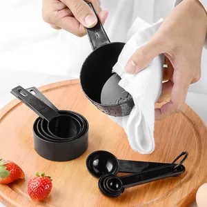 10-piece black plastic measuring cups and spoons set for baking on wooden board