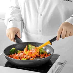 Cuchara de cocina de silicona amarilla con mango de PP negro para saltear verduras en sartén.