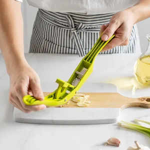 Efficient green 2-in-1 kitchen garlic press and slicer tool for crushing and mincing garlic
