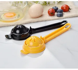 Detail view of black and yellow long-handle plastic egg white separators on white table