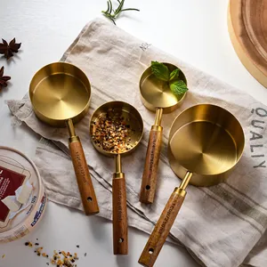 Set of 4 gold stainless steel measuring cups with ergonomic wooden handles for baking