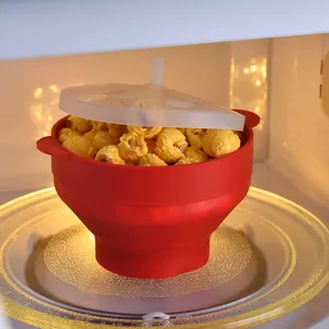 Faltbare rote Popcorn-Schüssel aus Silikon mit Deckel in einem Küchen-Mikrowellenherd