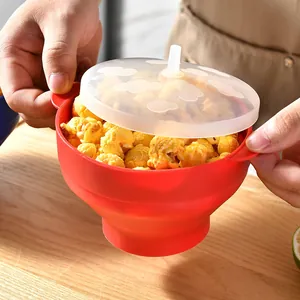 Rote faltbare Popcorn-Schüssel aus Silikon mit Deckel, gefüllt mit frischem Popcorn