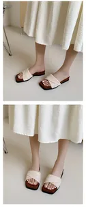 Detail shot of elegant woven wedge slide sandals worn with a pleated white summer dress