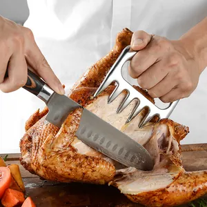 Stainless steel meat shredder claws being used to slice a whole roasted turkey