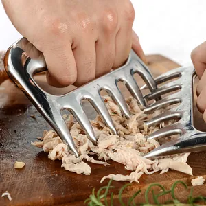 Stainless steel meat shredder claws for BBQ and turkey shredding on a wooden board