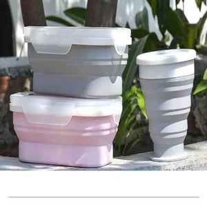 Stack of foldable silicone lunch boxes and a telescopic cup in an outdoor setting