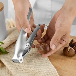 Heavy duty 304 stainless steel chestnut opener tool being used on a wooden board