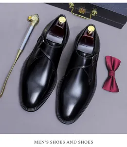 Vue de dessus de chaussures en cuir noir poli avec accessoires de bureau élégants.