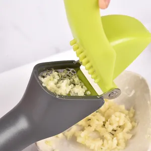 Efficient manual green and grey garlic press mincer with stainless steel crushing grate