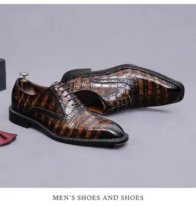 Detailed view of the crocodile pattern texture on brown men's leather Oxford shoes.