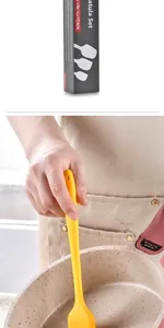 Detail of a yellow silicone basting brush with an ergonomic anti-scald handle