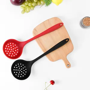 Heat-resistant red and black silicone slotted spoons on a wooden cutting board
