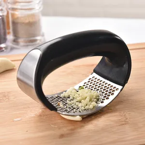 Professional ergonomic stainless steel manual garlic press rocker on a wooden board