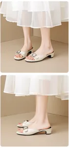 Detailed side and front view of elegant cream block heel sandals with buckle decoration