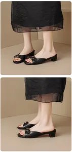 Detail view of elegant women's black block heel mules with stylish metal buckle.