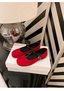 Close-up detail of French retro red suede Mary Jane flat shoes with elegant black strap