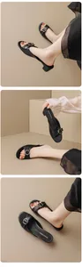 Detailed close-up view of black retro block heel slides with elegant decorative metal buckle