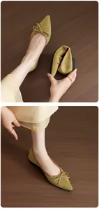 Detail view showing flexibility of olive green French retro ballet flats with bow and pointed toe