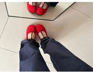 Top view of red vintage round-toe Mary Jane shoes with black T-strap on floor