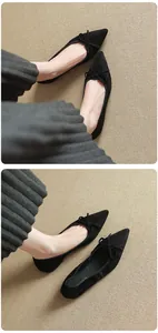Detailed close-up of French retro black pointed-toe ballet flats with bow decoration