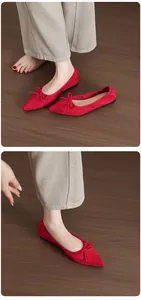 Detailed view of elegant red pointed-toe ballet flats featuring a vintage bow design