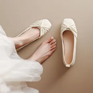 Ballerines élégantes en cuir souple blanc crème avec détail de nœud plissé et bout carré.