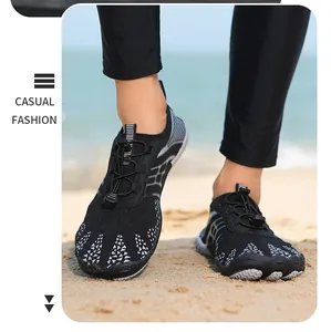 Gros plan détaillé de chaussures d'eau pieds nus noires sur une plage de sable avec maille.