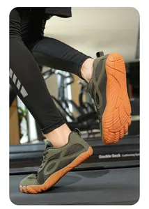 Dettaglio di scarpe a piedi nudi verde militare a punta larga su un tapis roulant in palestra.