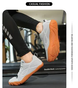 Scarpe a piedi nudi grigie flessibili con punta larga e suola arancione sul tapis roulant.
