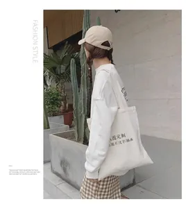Woman wearing a large white canvas tote bag in a minimalist outdoor setting.