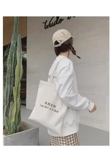 Detailed view of a minimalist white large-capacity canvas tote bag carried by a model.