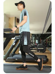 Uomo asiatico in palestra che indossa sneakers sportive nere traspiranti sul tapis roulant