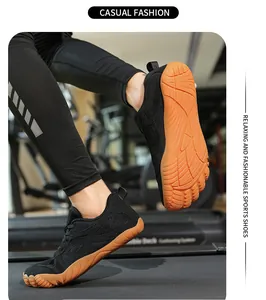 Primo piano di scarpe sportive a piedi nudi in mesh nero con suole in gomma arancione