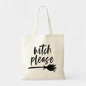 Close-up of 'witch please' slogan and broomstick illustration on a white canvas tote bag