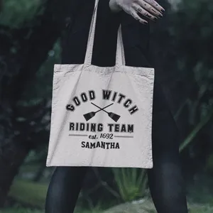Detail view of canvas tote bag with Good Witch Riding Team print and broom graphics
