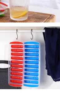Detail view of 10-cavity silicone finger ice cube trays hanging on kitchen hooks in white